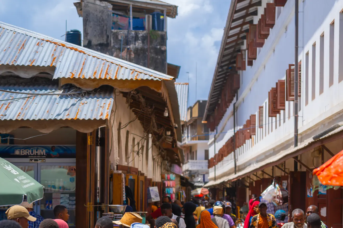 People walking beside market stalls in Stone Town, Zanzibar
