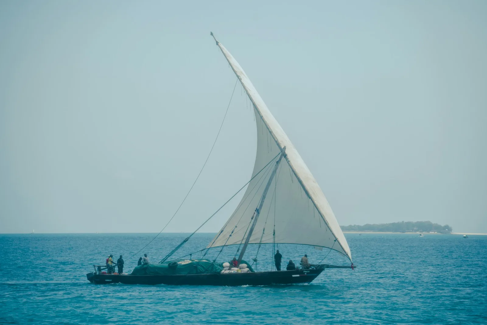 People aboard a traditional dhow sailing near Zanzibar port